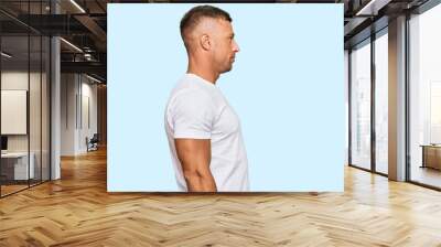 Handsome muscle man wearing casual white tshirt looking to side, relax profile pose with natural face and confident smile. Wall mural