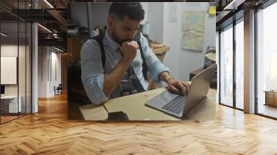 Hispanic detective man working on laptop in police station office with beard, adult, person, male, guy, indoor, workplace, room, interior Wall mural