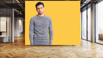 Hispanic handsome young man wearing casual sweater depressed and worry for distress, crying angry and afraid. sad expression. Wall mural