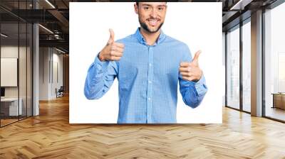 Hispanic man with beard wearing casual business shirt success sign doing positive gesture with hand, thumbs up smiling and happy. cheerful expression and winner gesture. Wall mural