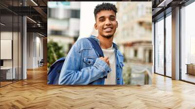 Hispanic young man smiling at the street Wall mural