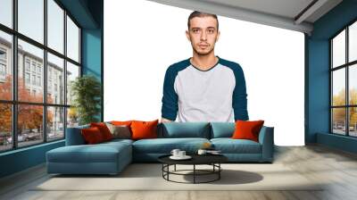 Hispanic young man wearing casual clothes with serious expression on face. simple and natural looking at the camera. Wall mural