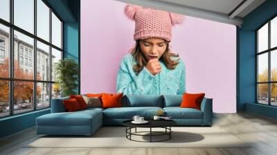 Little beautiful girl wearing wool sweater and cute winter hat feeling unwell and coughing as symptom for cold or bronchitis. health care concept. Wall mural