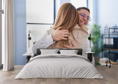 Man and woman business workers hugging each other at office Wall mural