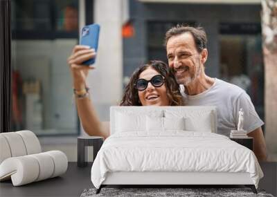 Man and woman couple hugging each other make selfie by smartphone at street Wall mural