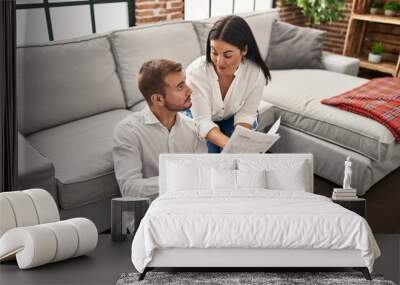 Man and woman couple smiling confident reading document at home Wall mural