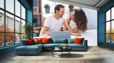 Man and woman couple smiling confident using laptop at home Wall mural