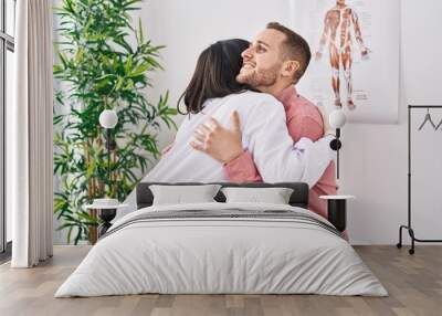 Man and woman doctor and patient hugging each other at clinic Wall mural