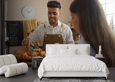 Man serving croissants to woman customer in bakery shop interior Wall mural