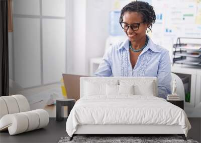 Middle age african american woman business worker using laptop working at office Wall mural