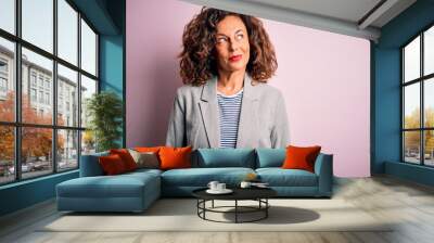 Middle age beautiful businesswoman wearing elegant jacket over isolated pink background smiling looking to the side and staring away thinking. Wall mural