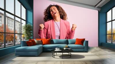 Middle age beautiful businesswoman wearing elegant jacket over isolated pink background very happy and excited doing winner gesture with arms raised, smiling and screaming for success. Celebration Wall mural