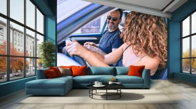 Middle age beautiful couple on vacation wearing sunglasses smiling happy driving car. Wall mural