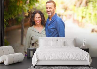 Middle age beautiful couple smiling happy and confident at town park. Standing with smile on face and hugging Wall mural