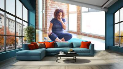 Middle age beautiful sportswoman wearing sportswear sitting on mat practicing yoga at home feeling unwell and coughing as symptom for cold or bronchitis. Healthcare concept. Wall mural