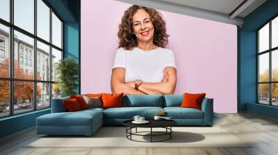 Middle age beautiful woman wearing casual t-shirt standing over isolated pink background happy face smiling with crossed arms looking at the camera. Positive person. Wall mural