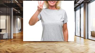 Middle age blonde woman over isolated background showing and pointing up with fingers number three while smiling confident and happy. Wall mural