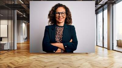 Middle age brunette business woman wearing glasses standing over isolated white background happy face smiling with crossed arms looking at the camera. Positive person. Wall mural