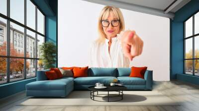 Middle age businesswoman wearing shirt and glasses standing over isolated white background pointing with finger to the camera and to you, hand sign, positive and confident gesture from the front Wall mural