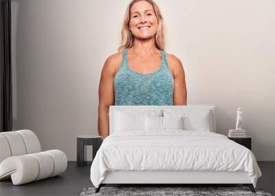 Middle age caucasian blonde woman wearing sportswear with a happy and cool smile on face. lucky person. Wall mural