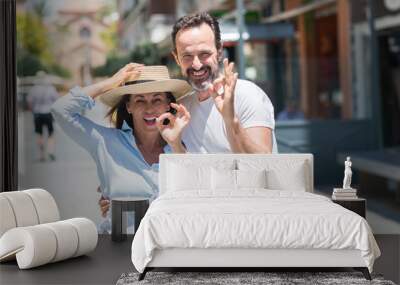 Middle age couple down the street doing ok sign with fingers, excellent symbol Wall mural