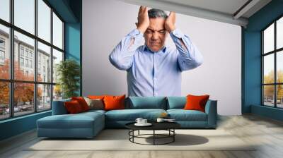 Middle age handsome grey-haired business man wearing elegant shirt over white background suffering from headache desperate and stressed because pain and migraine. Hands on head. Wall mural