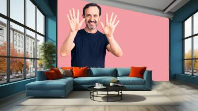 Middle age handsome man wearing casual t-shirt showing and pointing up with fingers number ten while smiling confident and happy. Wall mural