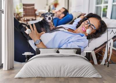 Middle age hispanic couple smiling confident lying on hammock with dog at terrace Wall mural