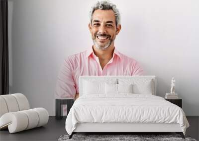 Middle age hispanic man standing over isolated background happy face smiling with crossed arms looking at the camera. positive person. Wall mural