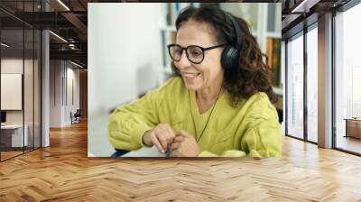 Middle age hispanic woman teacher using computer sitting on wheelchair at library university Wall mural