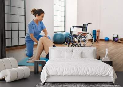 Middle age man and woman concentrate having rehab session stretching at physiotherapy clinic Wall mural