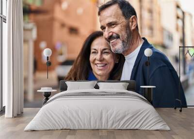 Middle age man and woman couple hugging each other standing at street Wall mural