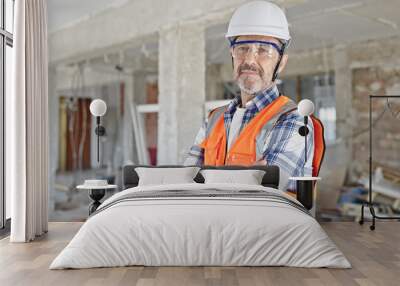 Middle age man builder standing with arms crossed gesture and relaxed expression at construction site Wall mural