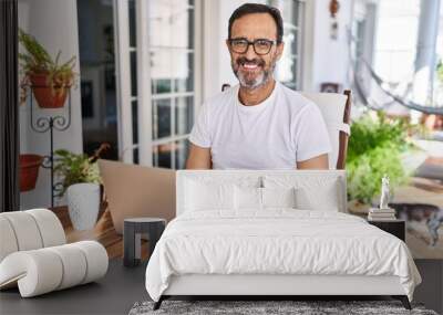 Middle age man using computer laptop at home with a happy and cool smile on face. lucky person. Wall mural