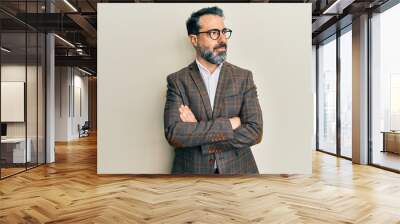 Middle age man with beard and grey hair wearing business jacket and glasses smiling looking to the side and staring away thinking. Wall mural