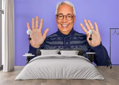 Middle age senior grey-haired man wearing glasses and winter sweater over purple background showing and pointing up with fingers number nine while smiling confident and happy. Wall mural