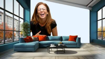 Middle age woman wearing black shirt and glasses confident and happy with a big natural smile laughing isolated blue background Wall mural