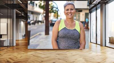 Middle age woman wearing sportswear standing at street Wall mural