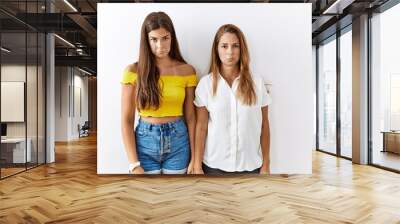 Mother and daughter together standing together over isolated background depressed and worry for distress, crying angry and afraid. sad expression. Wall mural