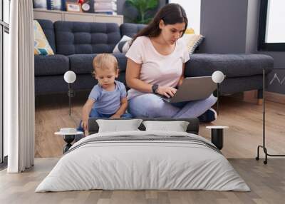 Mother and son using laptop and playing sitting on floor at home Wall mural