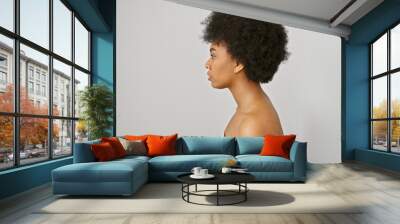 Portrait of a beautiful african american woman with curly hair against a white isolated background Wall mural