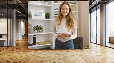 Portrait of a confident, smiling young hispanic woman at work, a beautiful, successful businesswoman holding documents in office Wall mural