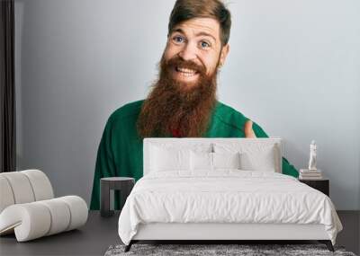 Redhead man with long beard wearing casual clothes doing happy thumbs up gesture with hand. approving expression looking at the camera showing success. Wall mural