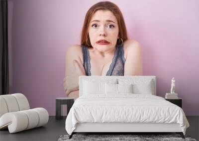 Redhead woman wearing lingerie over pink background shaking and freezing for winter cold with sad and shock expression on face Wall mural