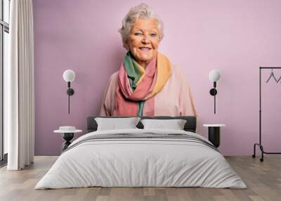 Senior beautiful grey-haired woman wearing casual sweater and scarf over pink background with a happy and cool smile on face. Lucky person. Wall mural