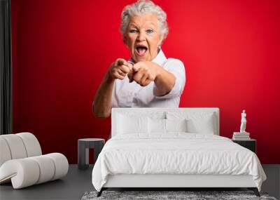 Senior beautiful woman wearing elegant shirt standing over isolated red background pointing to you and the camera with fingers, smiling positive and cheerful Wall mural