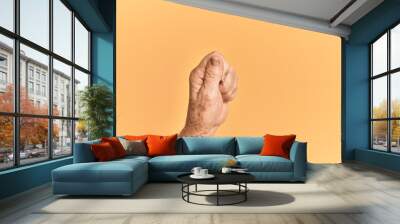 Senior caucasian hand over yellow isolated background holding blank space with thumb finger, business and advertising Wall mural