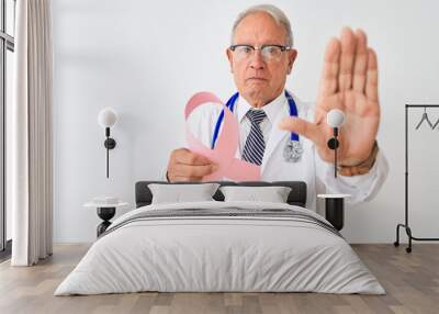 Senior grey-haired doctor man holding cancer ribbon over isolated white background with open hand doing stop sign with serious and confident expression, defense gesture Wall mural