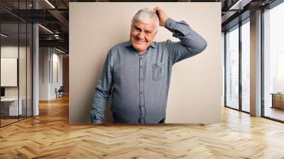 Senior handsome hoary man wearing casual shirt standing over isolated white background confuse and wonder about question. Uncertain with doubt, thinking with hand on head. Pensive concept. Wall mural