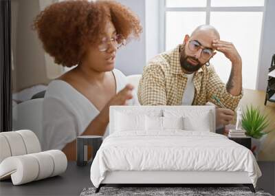 Serious man and woman coworkers stressed out, working together on laptop at office table Wall mural